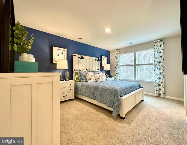 a bedroom with a bed and dresser with mirror