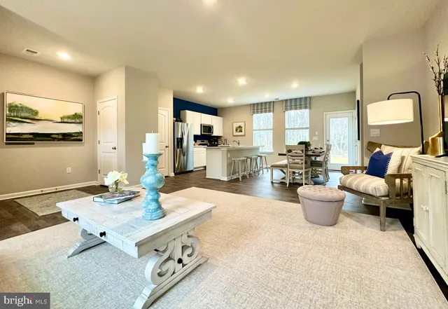 a living room with furniture and a view of kitchen