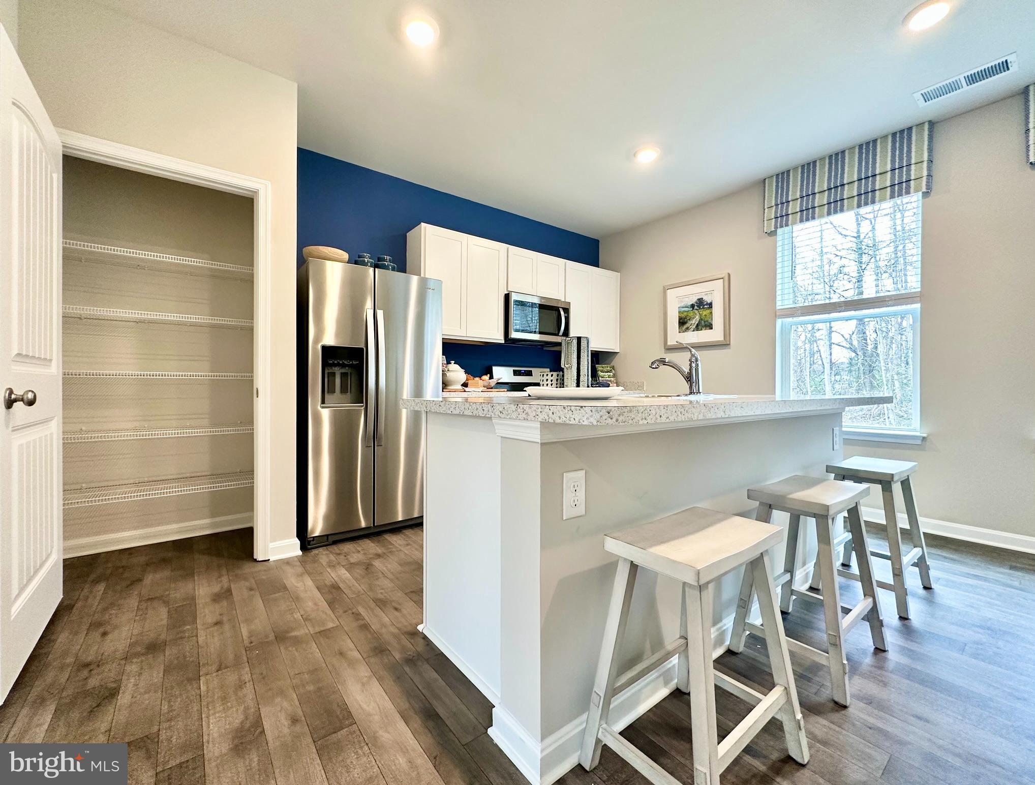104 Red Haven Way Dover, DE 19904 - Photo 9 of 33 a kitchen with a table chairs refrigerator and microwave