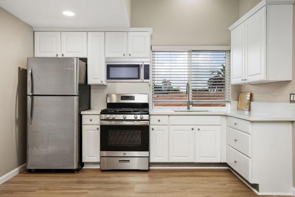 2380 Jefferson Street, Unit B Carlsbad, CA 92008 - Photo 12 of 25 a kitchen with cabinets stainless steel appliances and wooden floor