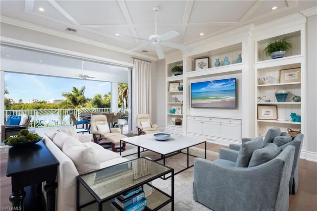 a living room with furniture a flat screen tv and a floor to ceiling window
