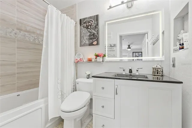 a bathroom with a granite countertop toilet sink and a mirror
