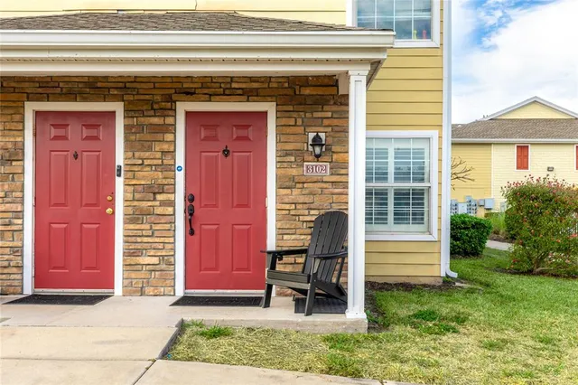 a front view of a house with a garden and a chair