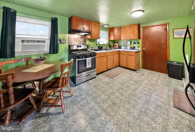 a kitchen with stainless steel appliances kitchen island granite countertop a refrigerator and a stove top oven