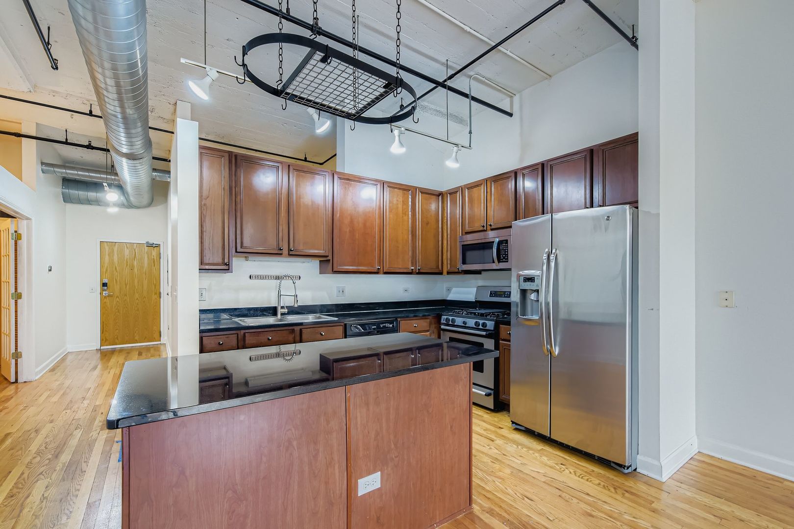 221 East Cullerton Street, Unit 317 Chicago, IL 60616 - Photo 10 of 16 a kitchen with stainless steel appliances granite countertop a refrigerator a stove and a wooden floors