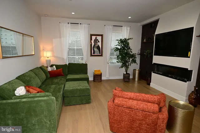 a living room with furniture a flat screen tv and a large window
