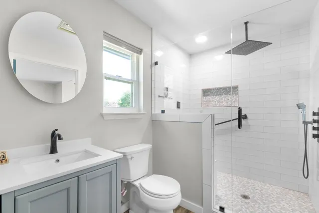 a bathroom with a sink a toilet and shower