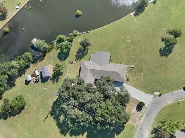 an aerial view of a house with a yard and lake view