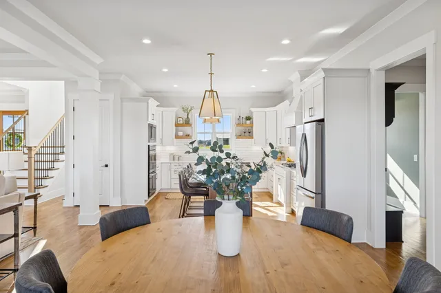 a view of a hallway with dining room and wooden floor