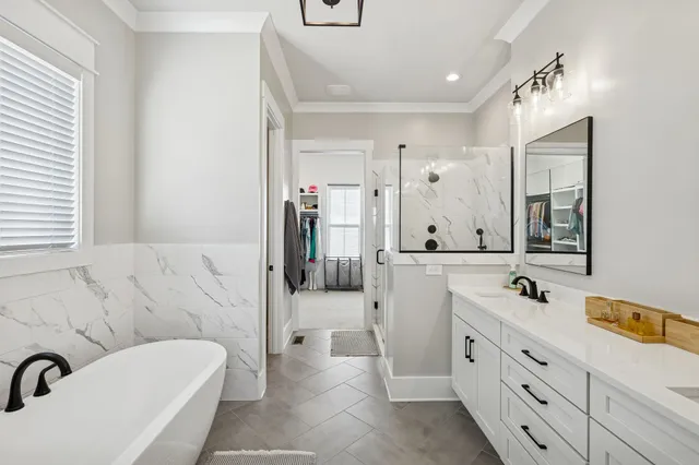a white bath tub sitting in a bathroom next to a window