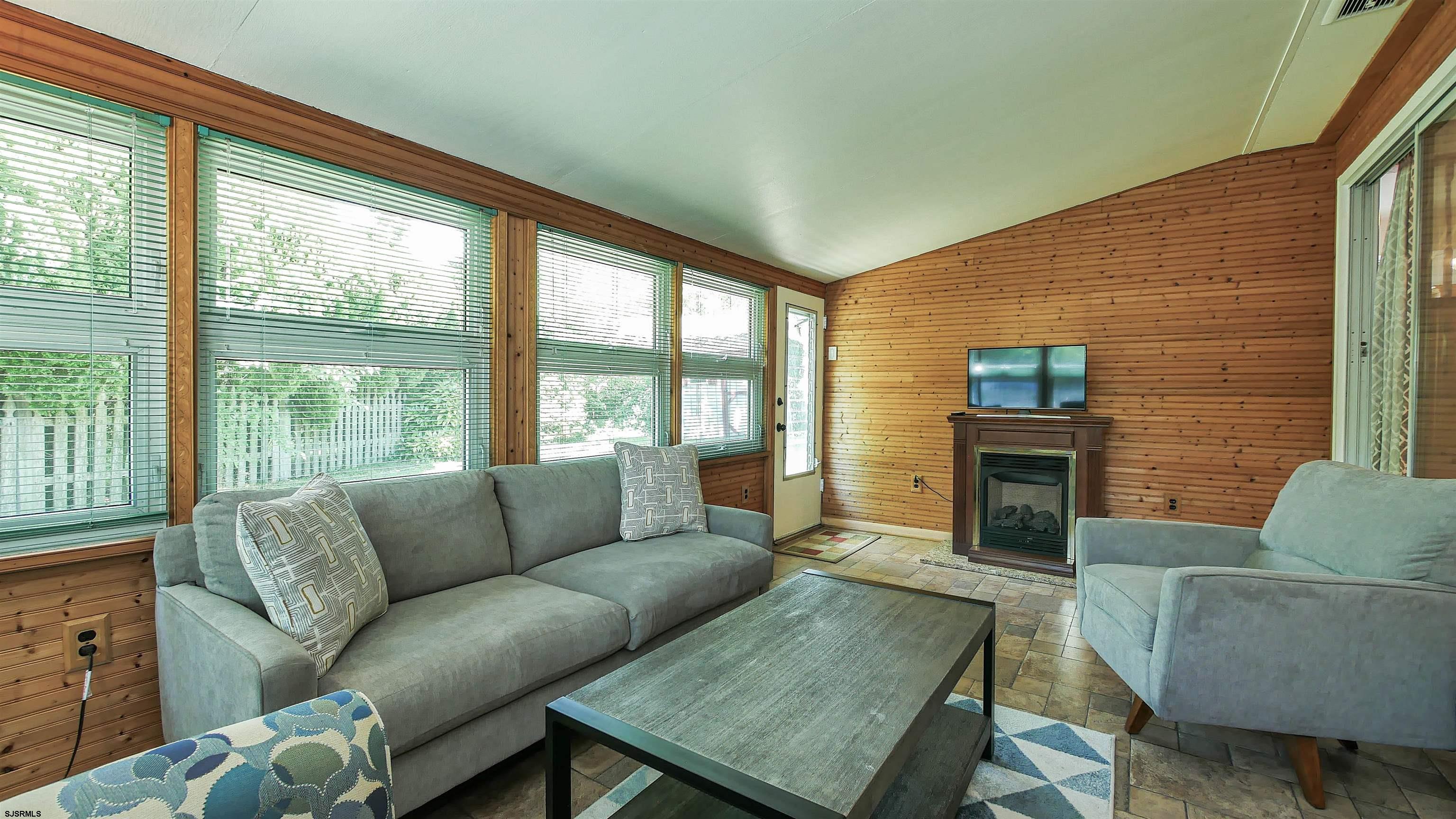 8 Malvern Road Somers Point, NJ 08244 - Photo 13 of 31 a living room with furniture a fireplace and a floor to ceiling window