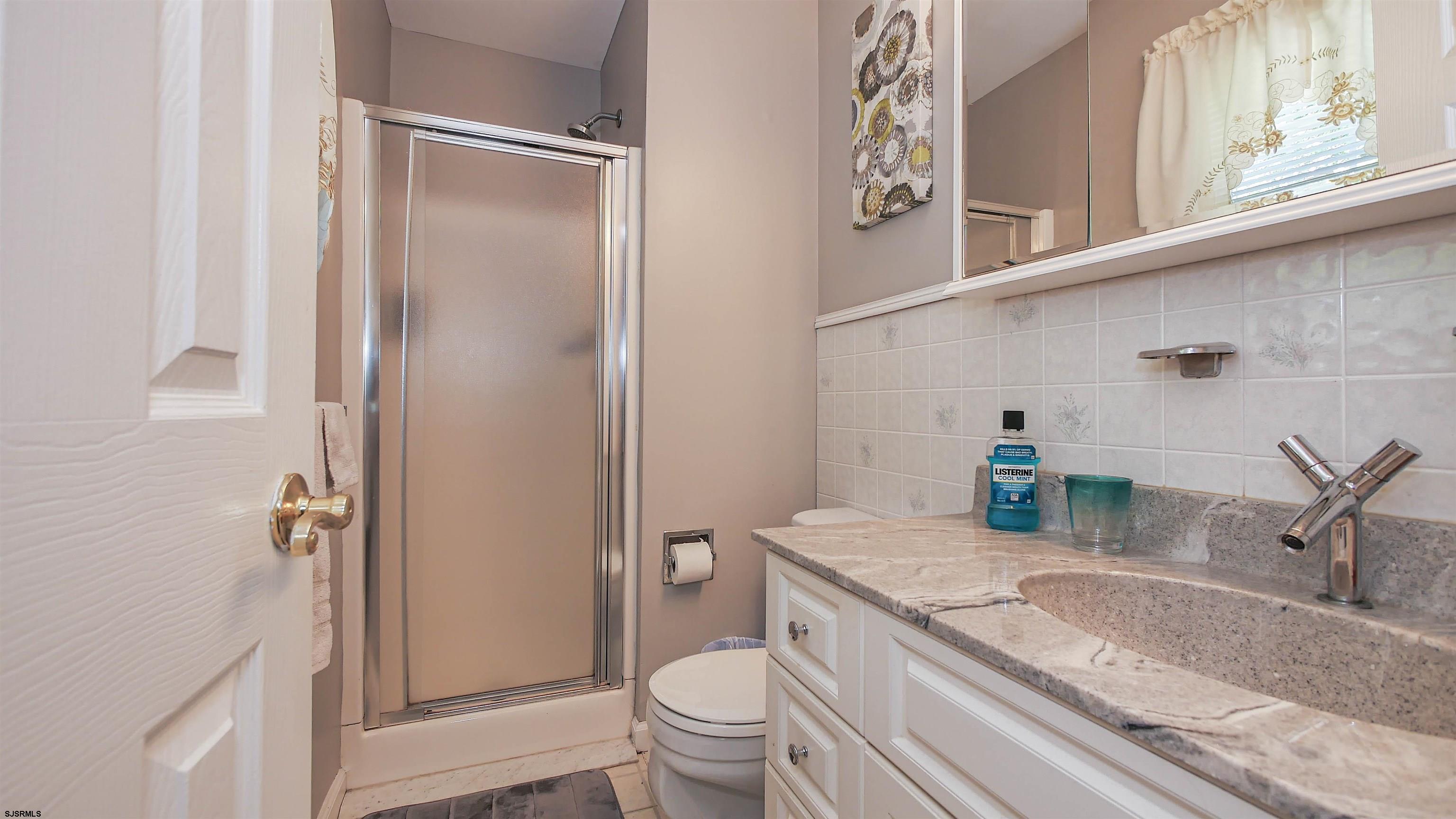 8 Malvern Road Somers Point, NJ 08244 - Photo 21 of 31 a bathroom with a granite countertop sink a toilet and a shower