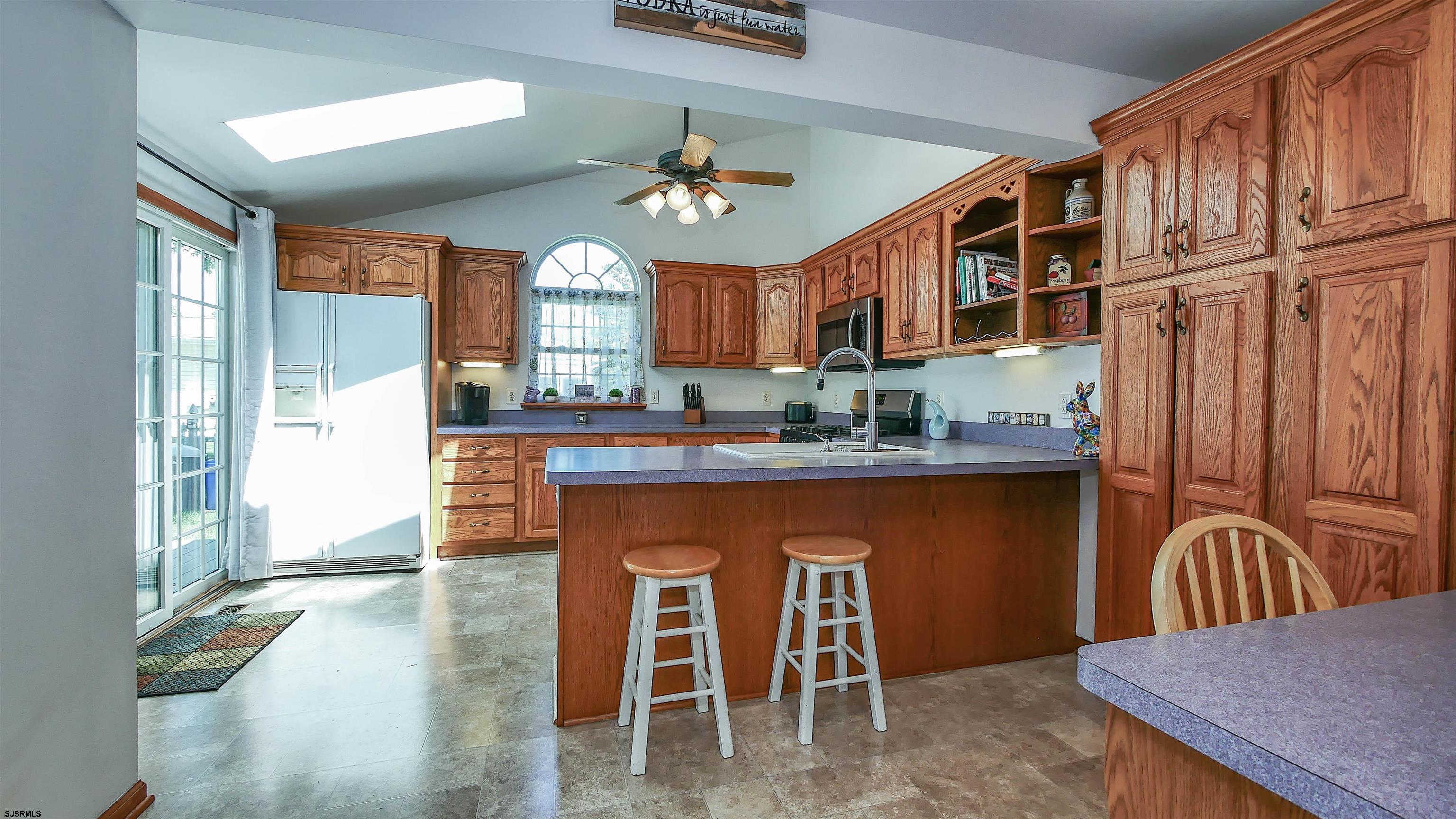 8 Malvern Road Somers Point, NJ 08244 - Photo 9 of 31 a kitchen with stainless steel appliances granite countertop a stove a refrigerator a sink a dining table and chairs with wooden floor