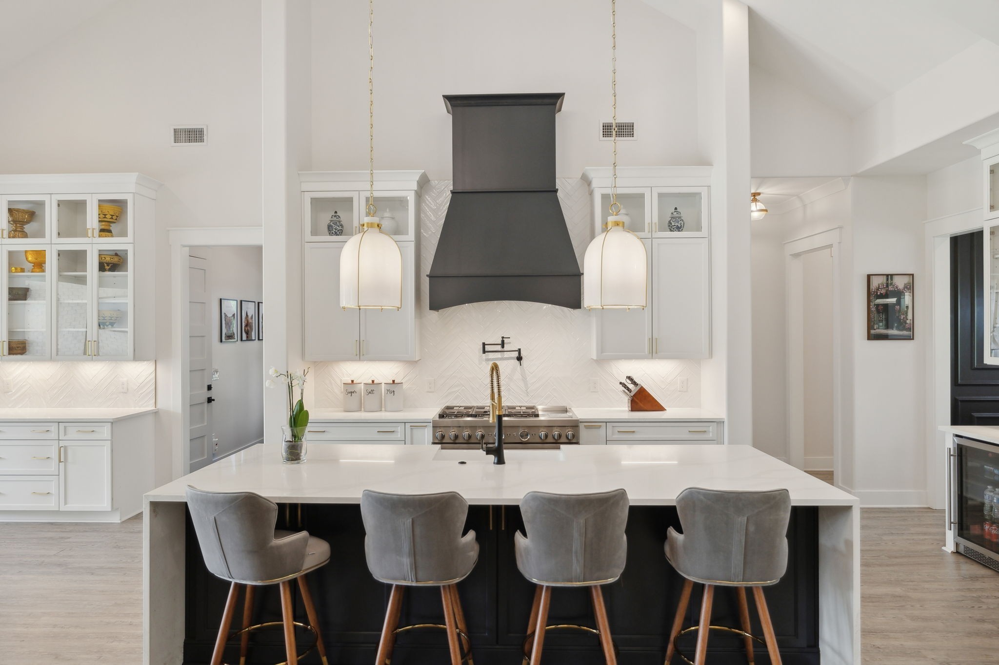 a kitchen with a dining table chairs and white cabinets