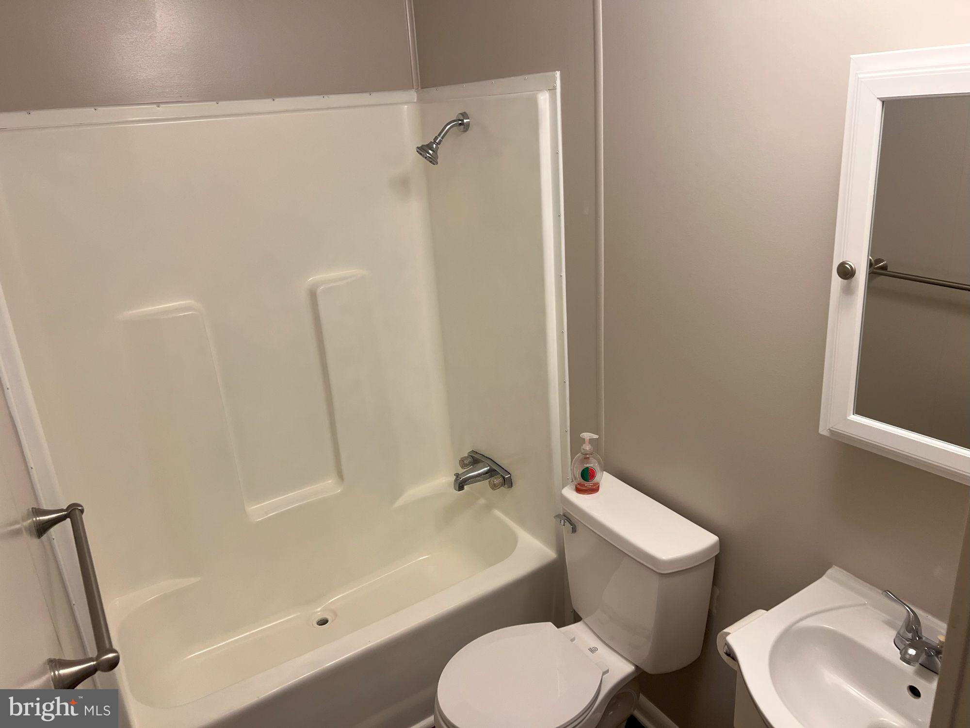 128 Ivy Ridge Court, Unit 128 Smyrna, DE 19977 - Photo 12 of 12 a white toilet sitting next to a bath tub