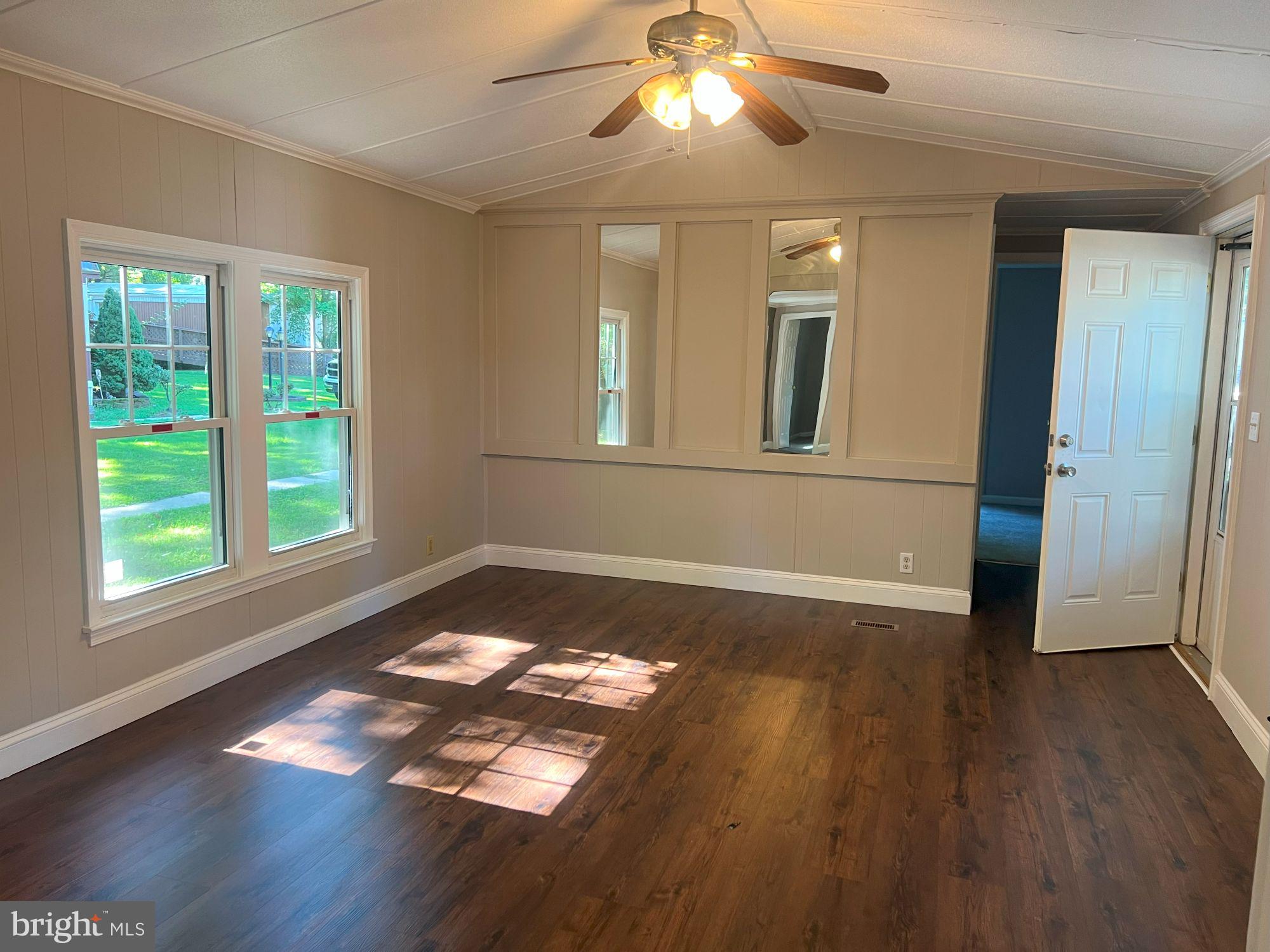 128 Ivy Ridge Court, Unit 128 Smyrna, DE 19977 - Photo 5 of 12 a view of an empty room with wooden floor and a window