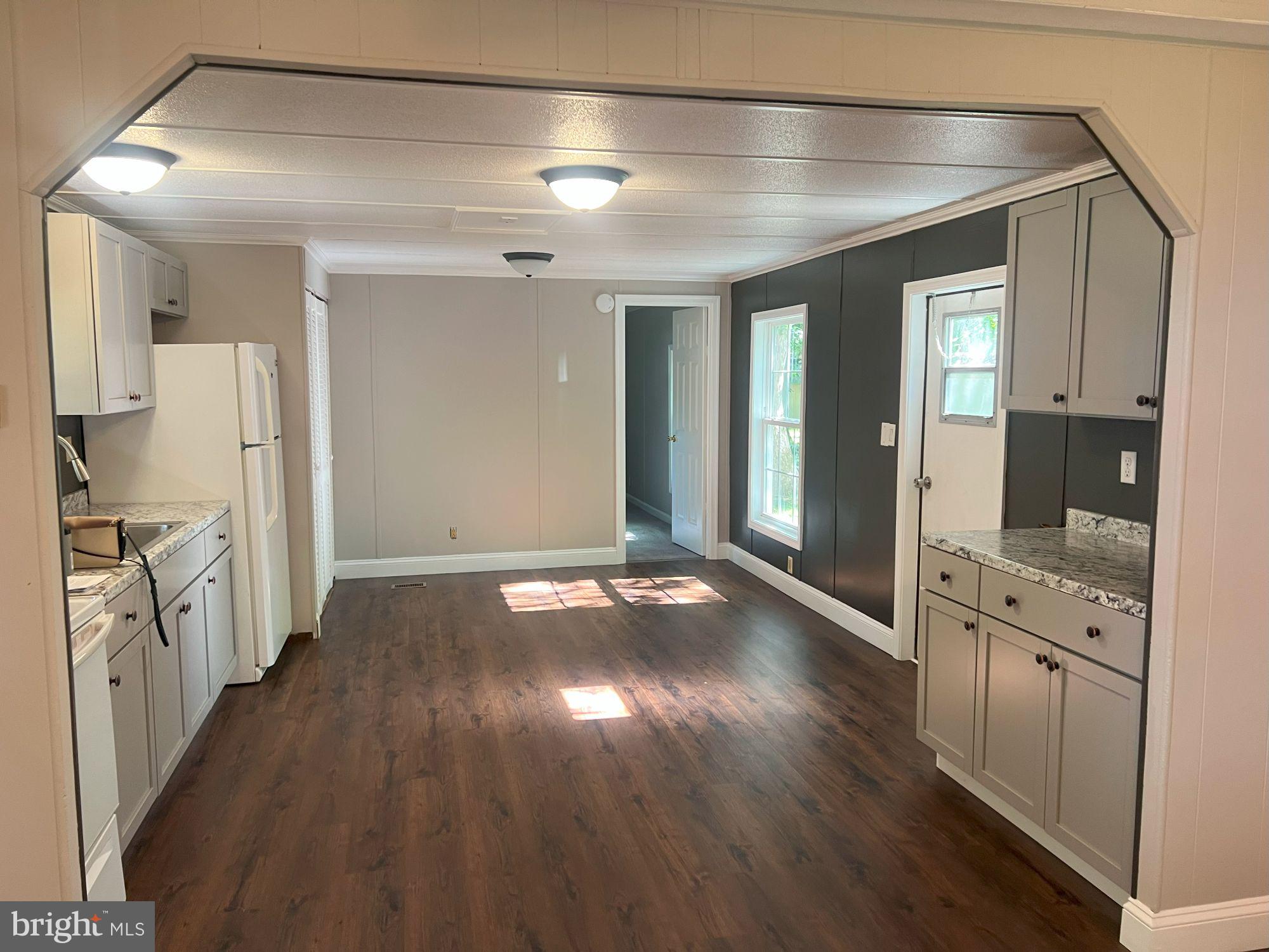 128 Ivy Ridge Court, Unit 128 Smyrna, DE 19977 - Photo 6 of 12 a view of a hallway with wooden floor and a living room