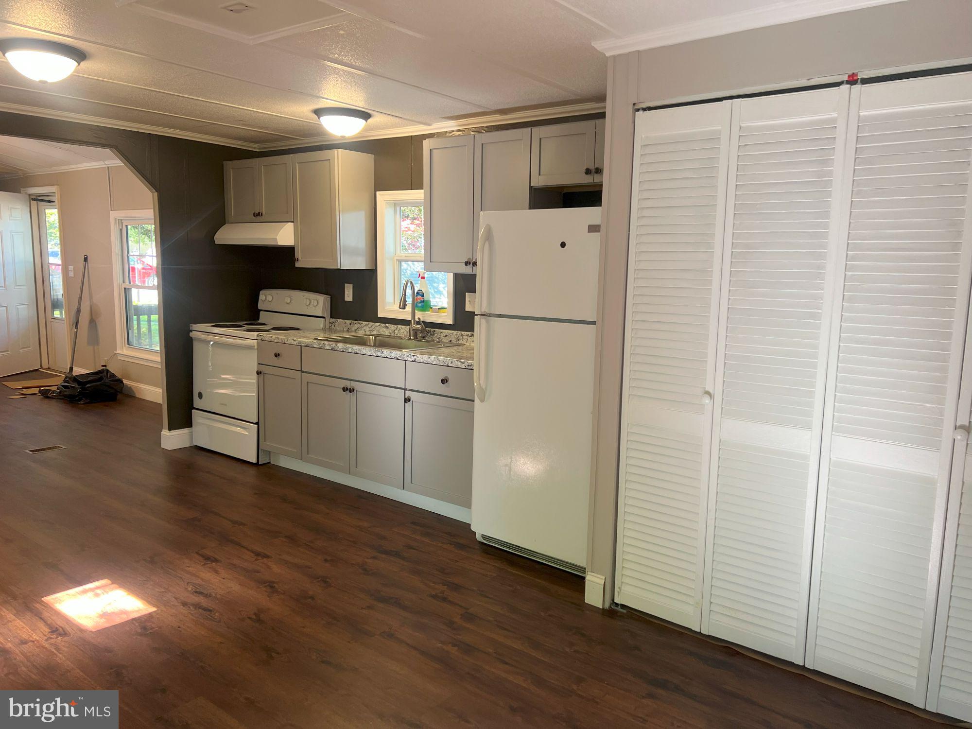 128 Ivy Ridge Court, Unit 128 Smyrna, DE 19977 - Photo 7 of 12 a kitchen with a refrigerator a stove and wooden floor