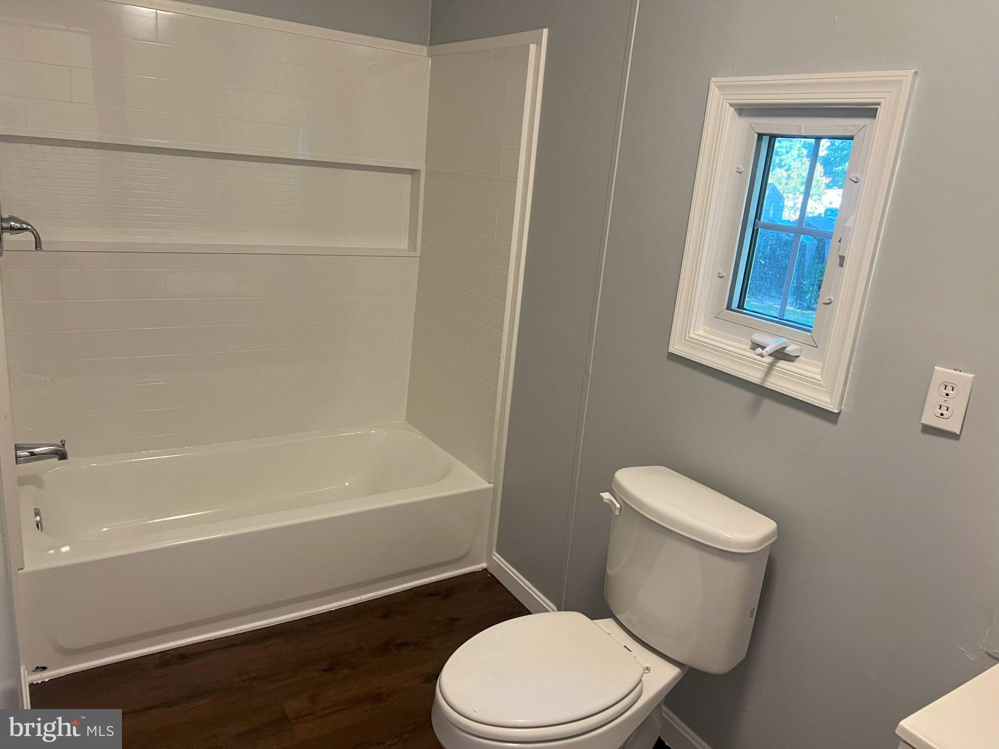 128 Ivy Ridge Court, Unit 128 Smyrna, DE 19977 - Photo 10 of 12 a white toilet sitting next to a bath tub
