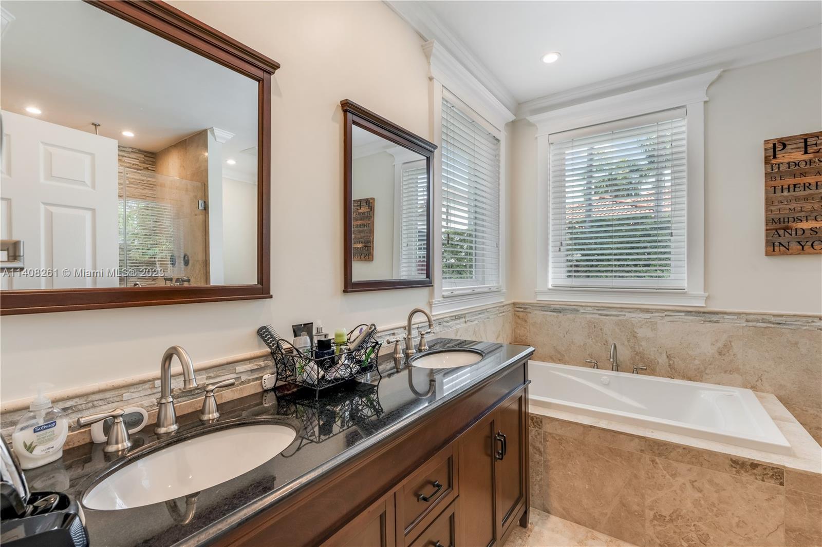 13151 Northwest 7th Street Miami, FL 33172 - Photo 29 of 48 a bathroom with double vanity sinks a large mirror and a bathtub