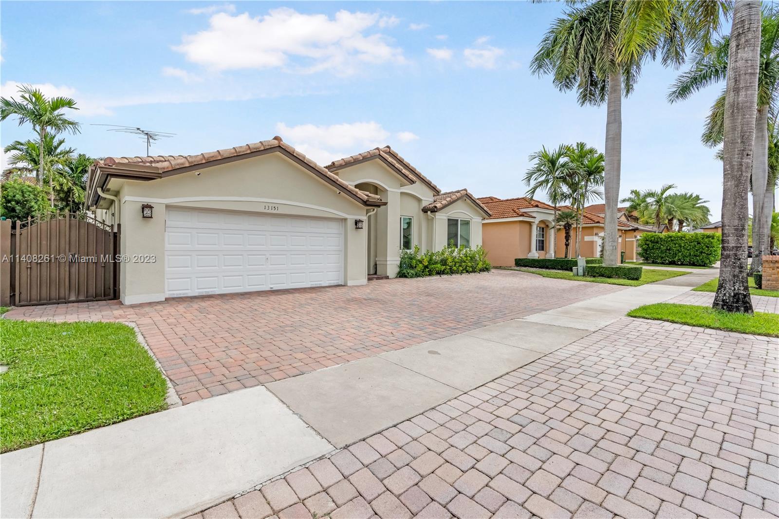 13151 Northwest 7th Street Miami, FL 33172 - Photo 4 of 48 a front view of a house with a garden and trees