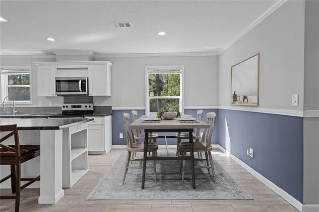 a kitchen with stainless steel appliances kitchen island granite countertop a stove a sink and a refrigerator
