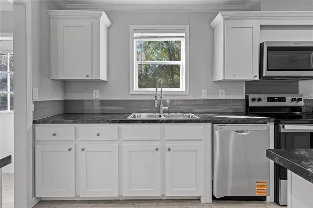 a kitchen with stainless steel appliances granite countertop a stove a sink refrigerator and a refrigerator