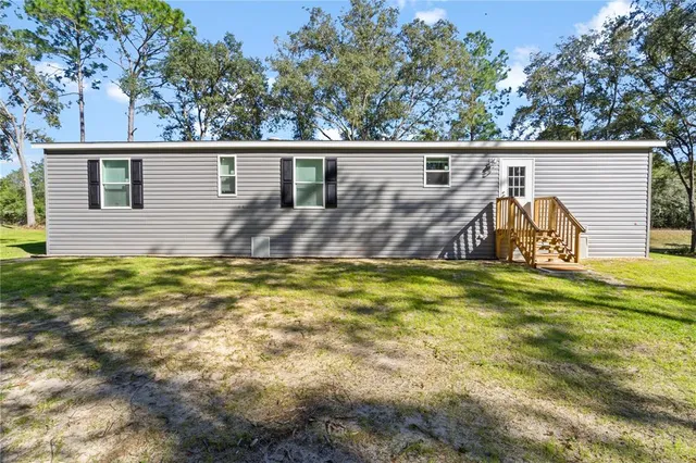 a view of a backyard with plants and a small pool