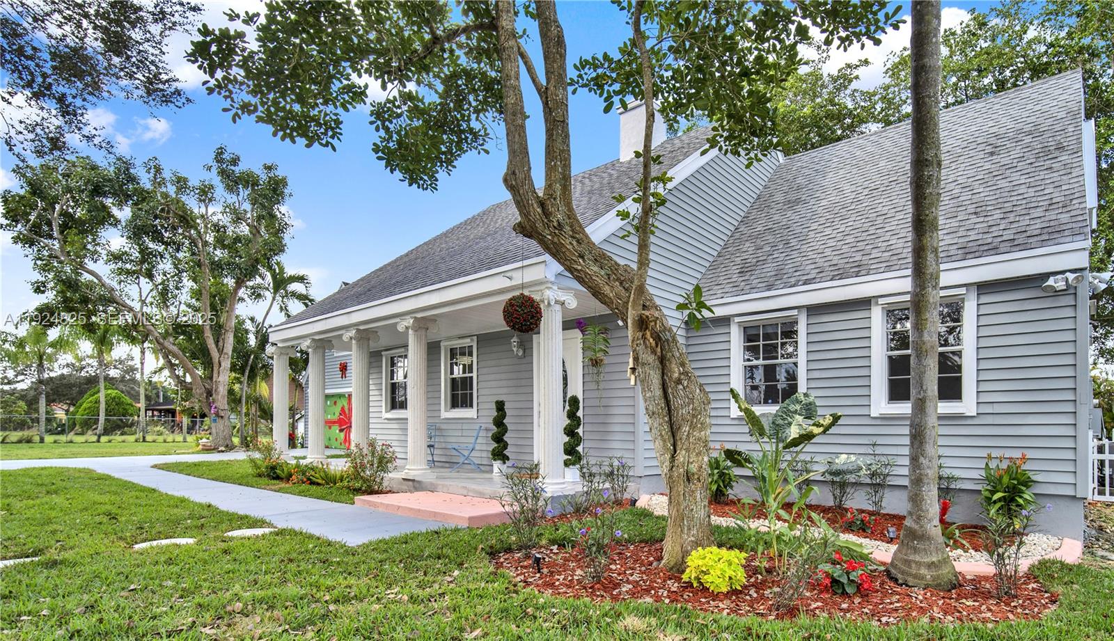 22820 Southwest 179th Place Miami, FL 33170 - Photo 4 of 56 a front view of a house with a yard and potted plants