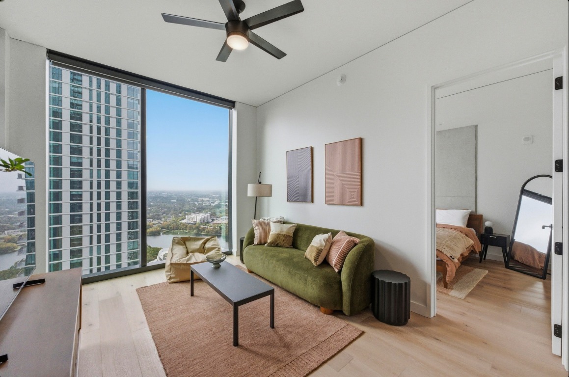610 Davis Street, Unit 3104 Austin, TX 78701 - Photo 1 of 40 Living room with a wall of windows, light wood-type flooring, a ceiling fan, and a view of city