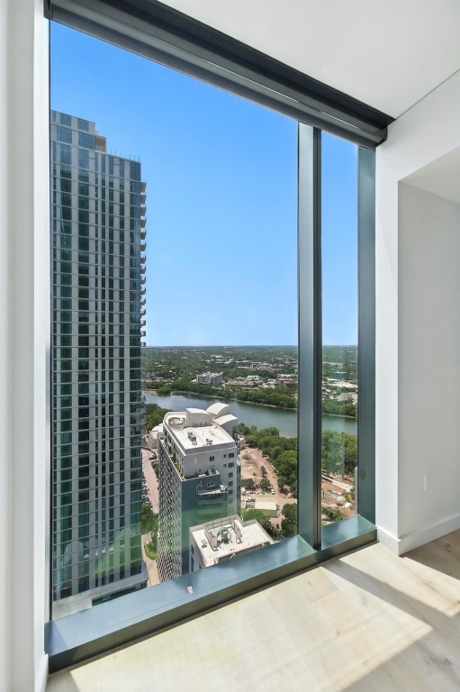 610 Davis Street, Unit 3104 Austin, TX 78701 - Photo 11 of 40 Doorway to outside featuring a water view, a wall of windows, wood finished floors, and a city view