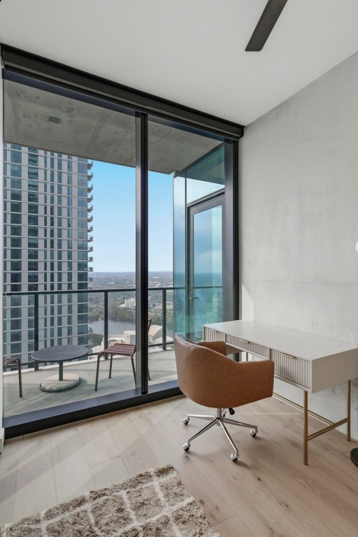 610 Davis Street, Unit 3104 Austin, TX 78701 - Photo 17 of 40 Home office featuring floor to ceiling windows, light wood-style flooring, and a water view