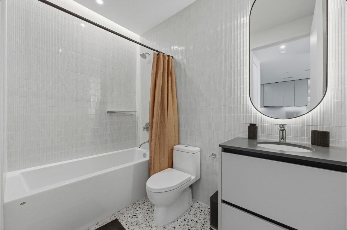 610 Davis Street, Unit 3104 Austin, TX 78701 - Photo 18 of 40 Full bath with tile walls, vanity, and shower / bath combination with curtain