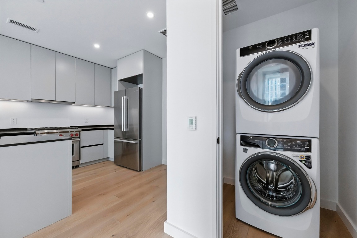 610 Davis Street, Unit 3104 Austin, TX 78701 - Photo 19 of 40 Washroom with light wood-style floors, stacked washer / drying machine, and recessed lighting