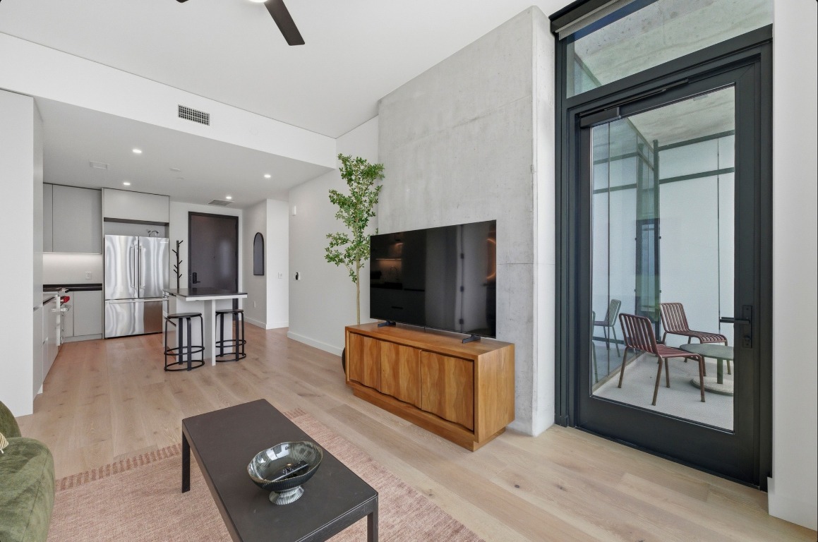 610 Davis Street, Unit 3104 Austin, TX 78701 - Photo 3 of 40 Living room featuring a ceiling fan and light wood-style flooring