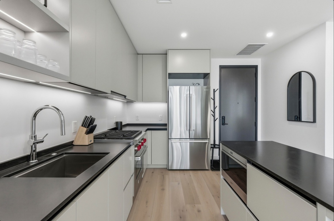 610 Davis Street, Unit 3104 Austin, TX 78701 - Photo 9 of 40 Kitchen featuring appliances with stainless steel finishes, modern cabinets, light wood finished floors, and recessed lighting