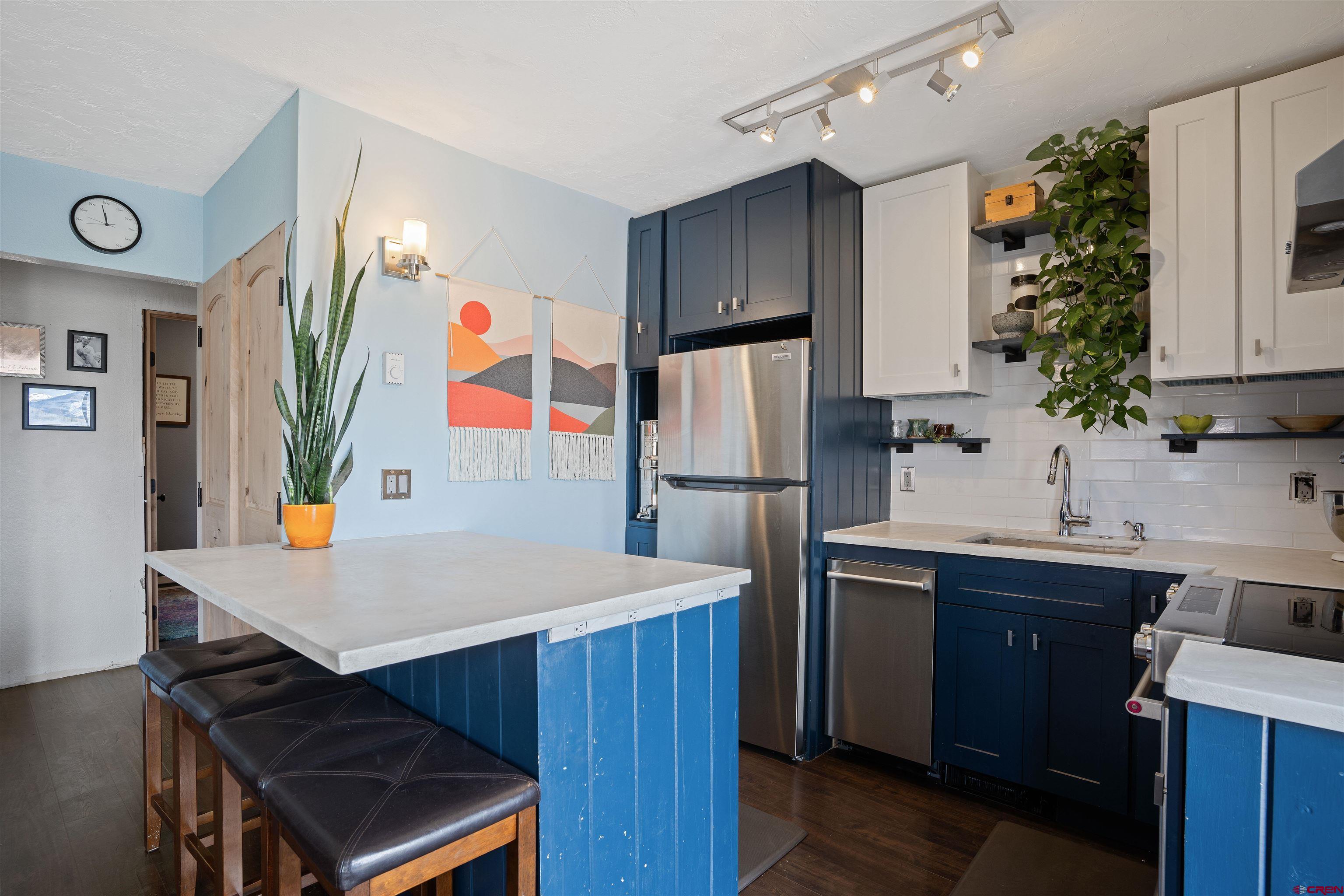 31 Castle Road, Unit 1 Crested Butte, CO 81225 - Photo 4 of 17 a kitchen with stainless steel appliances a sink dishwasher a refrigerator and a stove with wooden floor
