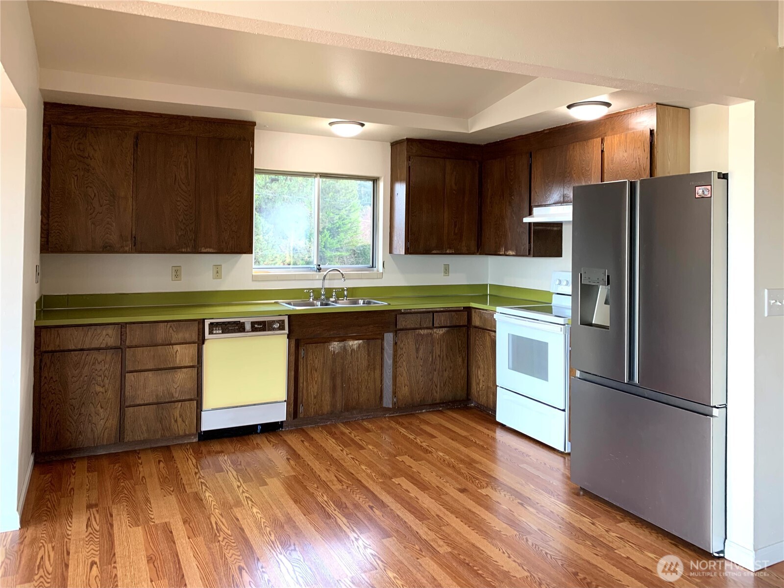 29818 4th Avenue Southwest Federal Way, WA 98023 - Photo 12 of 40 a kitchen with wooden floors and stainless steel appliances