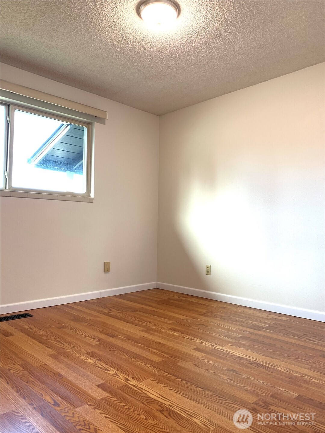29818 4th Avenue Southwest Federal Way, WA 98023 - Photo 23 of 40 a view of an empty room with wooden floor and a window