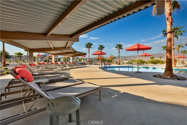 an outdoor space with patio couches table and chairs under an umbrella