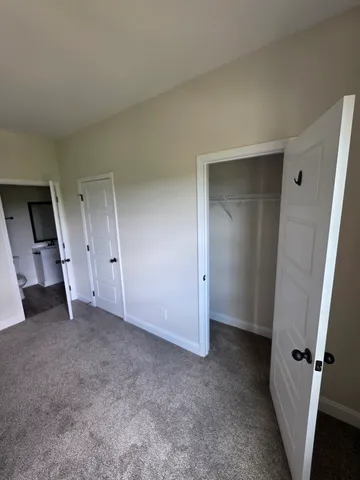 an empty room with an entryway and closet