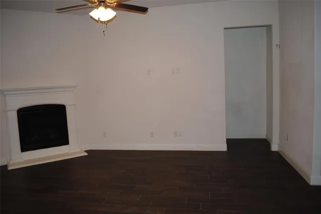 a view of a livingroom with wooden floor and a fireplace