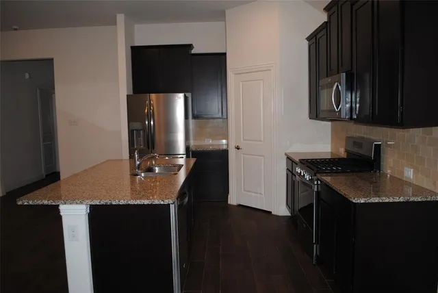 a kitchen with a sink refrigerator and cabinets