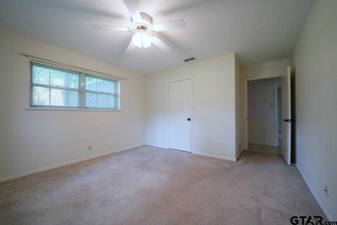 4505 Inverness Drive Tyler, TX 75703 - Photo 30 of 46 an empty room with chandelier fan and windows