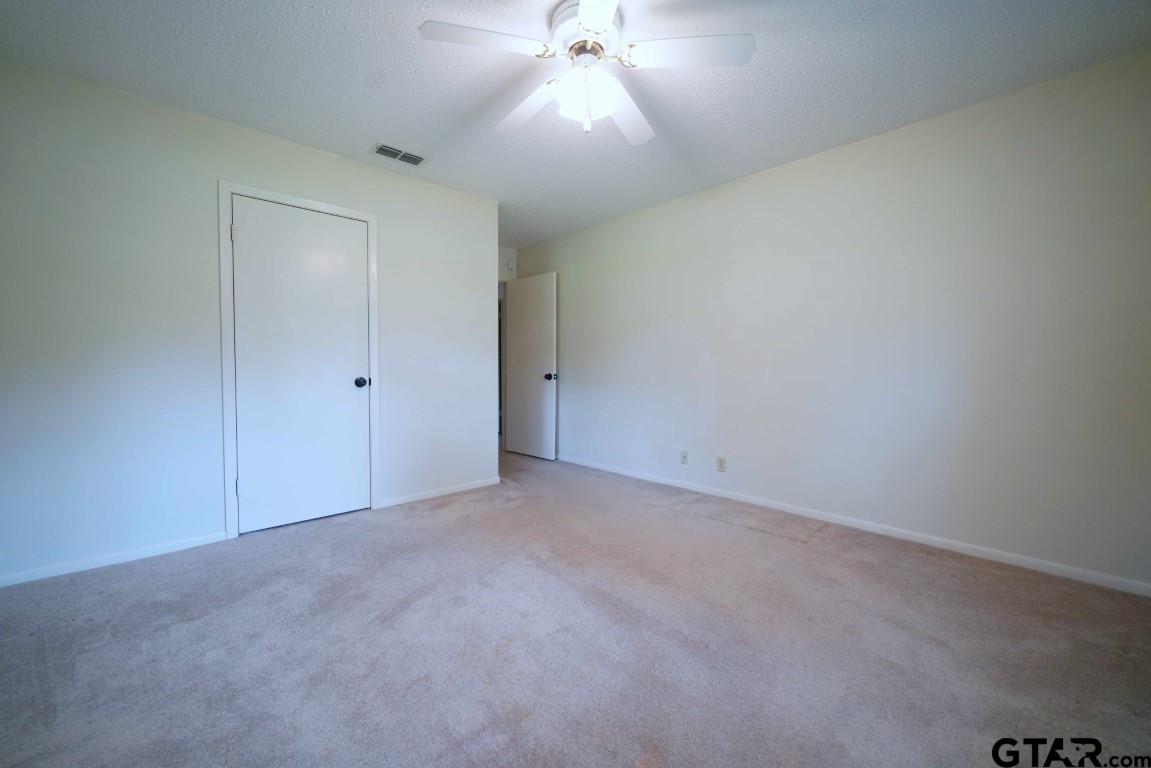4505 Inverness Drive Tyler, TX 75703 - Photo 31 of 46 an empty room with a ceiling fan and window
