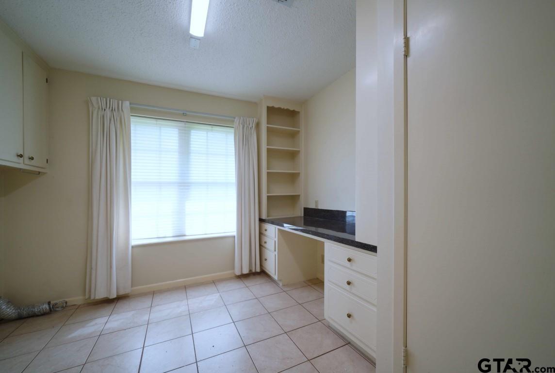 4505 Inverness Drive Tyler, TX 75703 - Photo 9 of 46 a kitchen with white cabinets and appliances