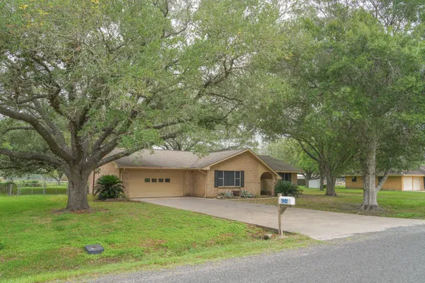 a front view of a house with a yard and tree s