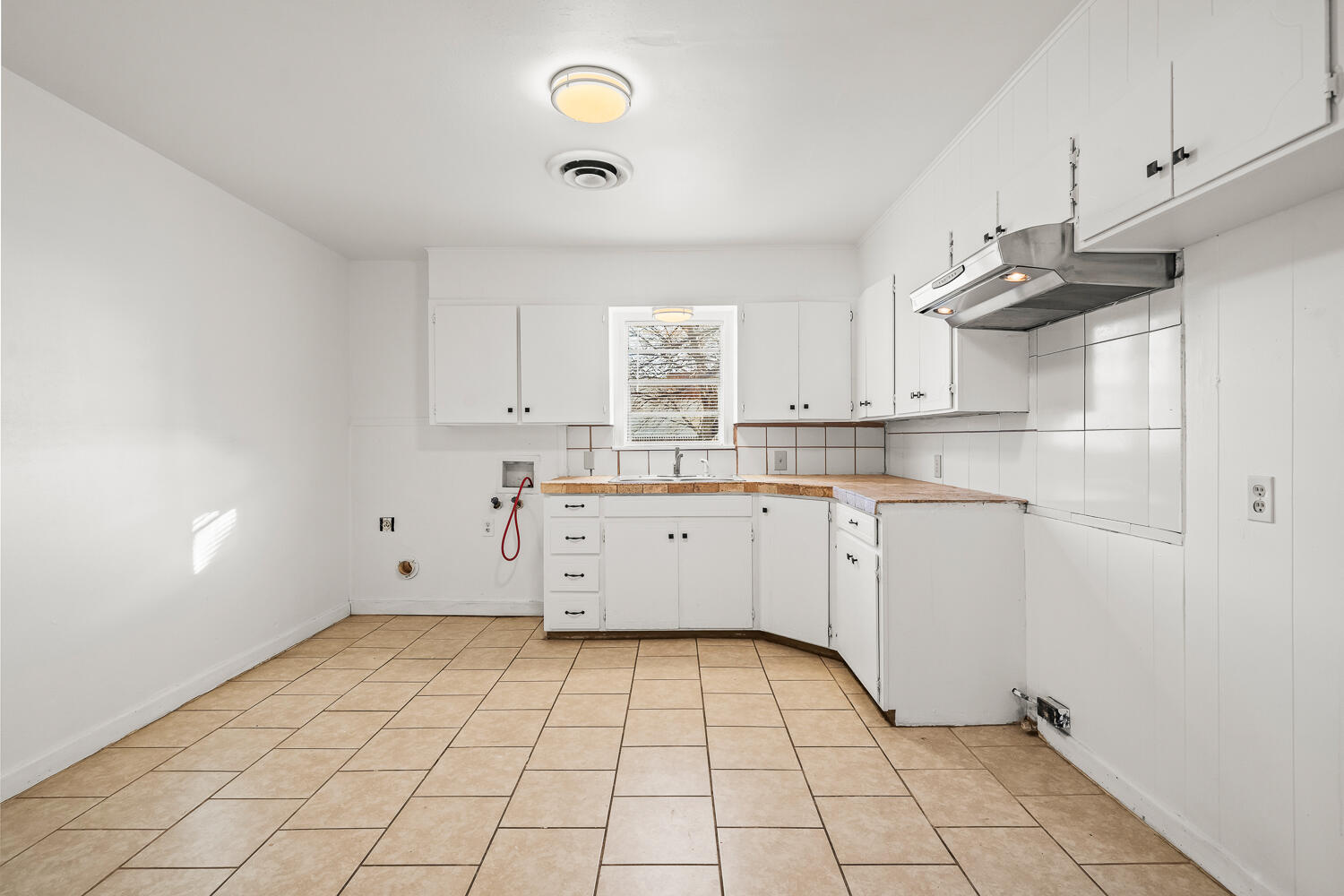 1609 39th Street Lubbock, TX 79412 - Photo 17 of 23 a kitchen with white cabinets a sink dishwasher and a stove with wooden floor