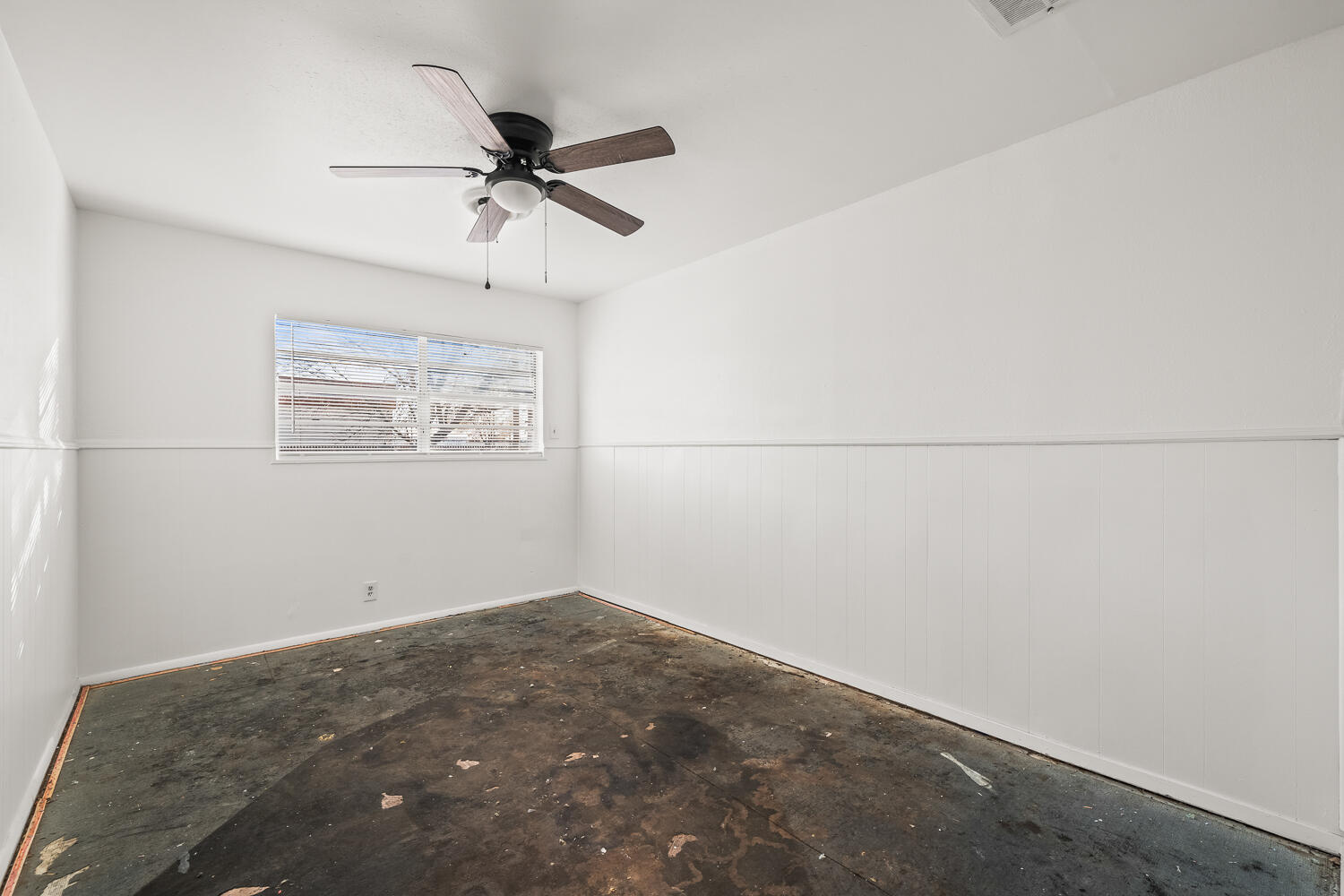 1609 39th Street Lubbock, TX 79412 - Photo 8 of 23 an empty room with a window and a ceiling fan