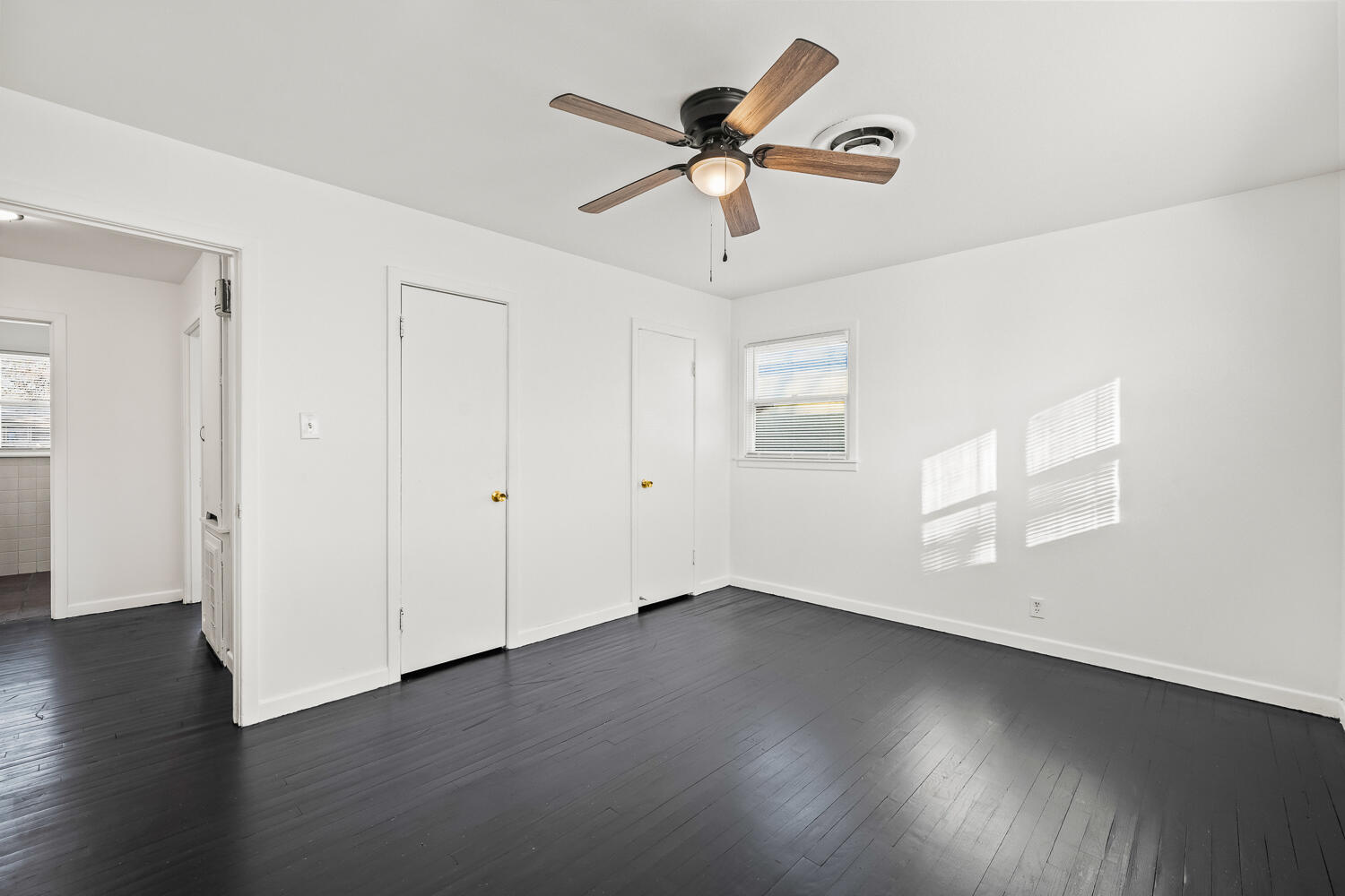 1609 39th Street Lubbock, TX 79412 - Photo 9 of 23 a view of an empty room with wooden floor and a ceiling fan